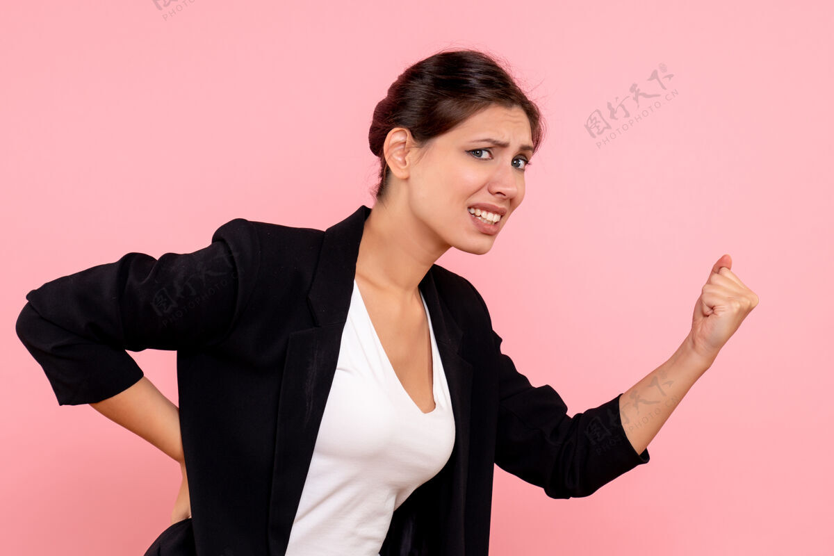 商务正面图年轻女性穿着粉色背景的深色夹克情感深色夹克