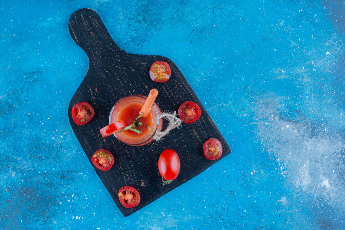 美味美味的番茄片和番茄汁在黑板上 蓝色背景高品质的照片玻璃蔬菜农业