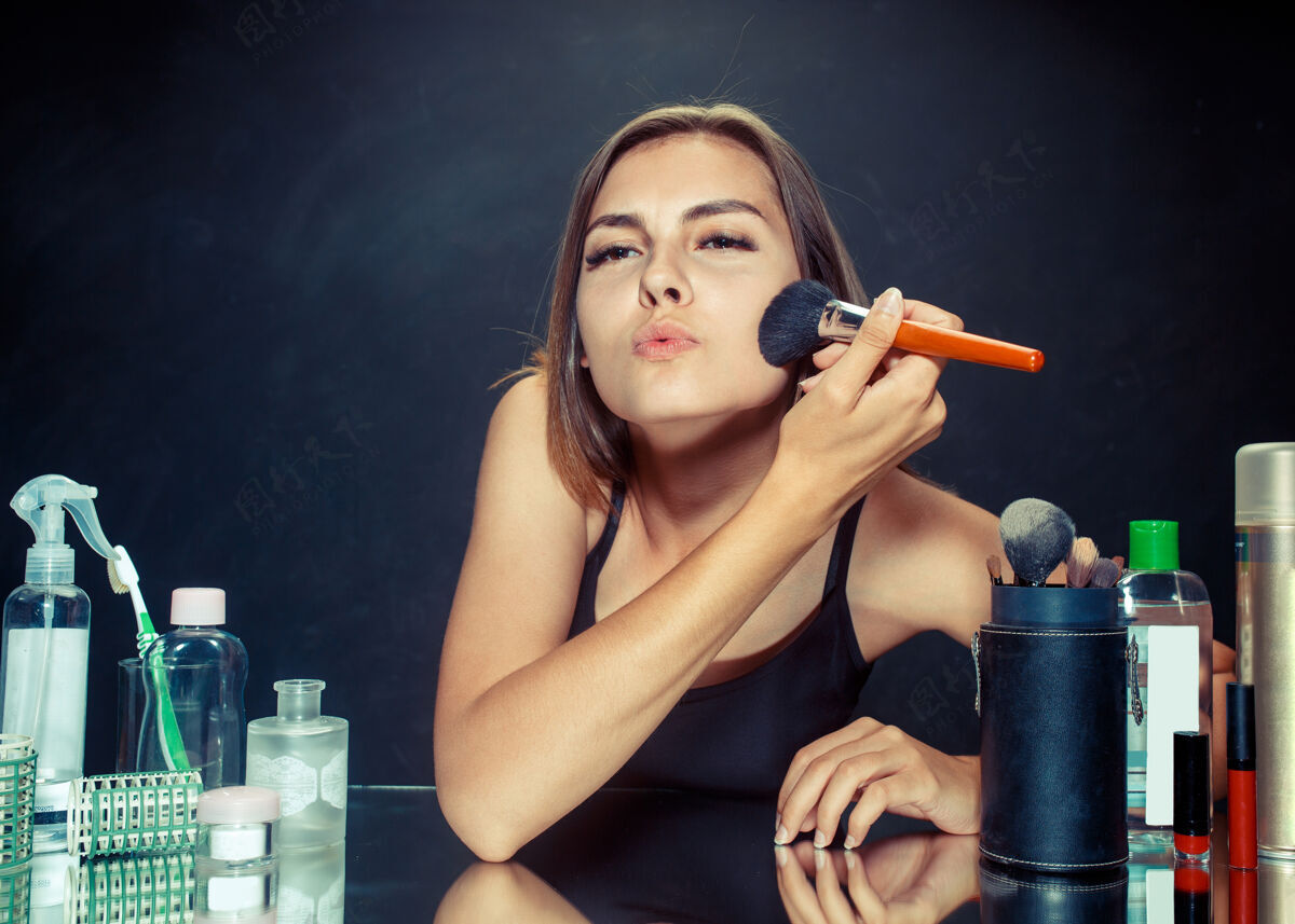 卧室美女化妆美女照镜子 用大刷子化妆早上好 化妆和人类情感概念工作室的白种人模特女性粉末制造