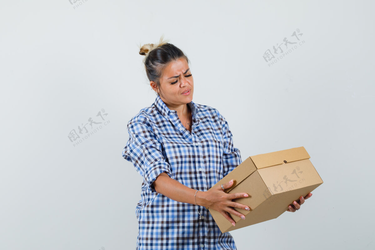 正面穿格子衬衫的年轻女子看着盒子 神情专注外观焦点方格