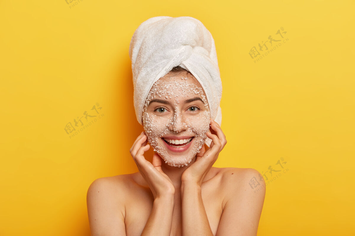 清洁美容可掬的快乐女人疏通毛孔 让美丽的脚步改善皮肤 涂上滋养的面部磨砂膏 柔顺肤色 双手放在脸颊上年轻姿势愈合