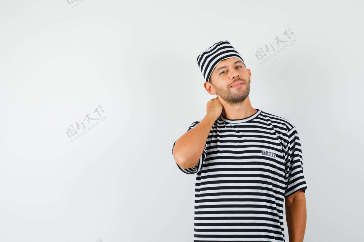 胡茬年轻人摆姿势 手放在脖子上 穿着条纹t恤 戴着帽子 看起来很优雅时尚男性商人
