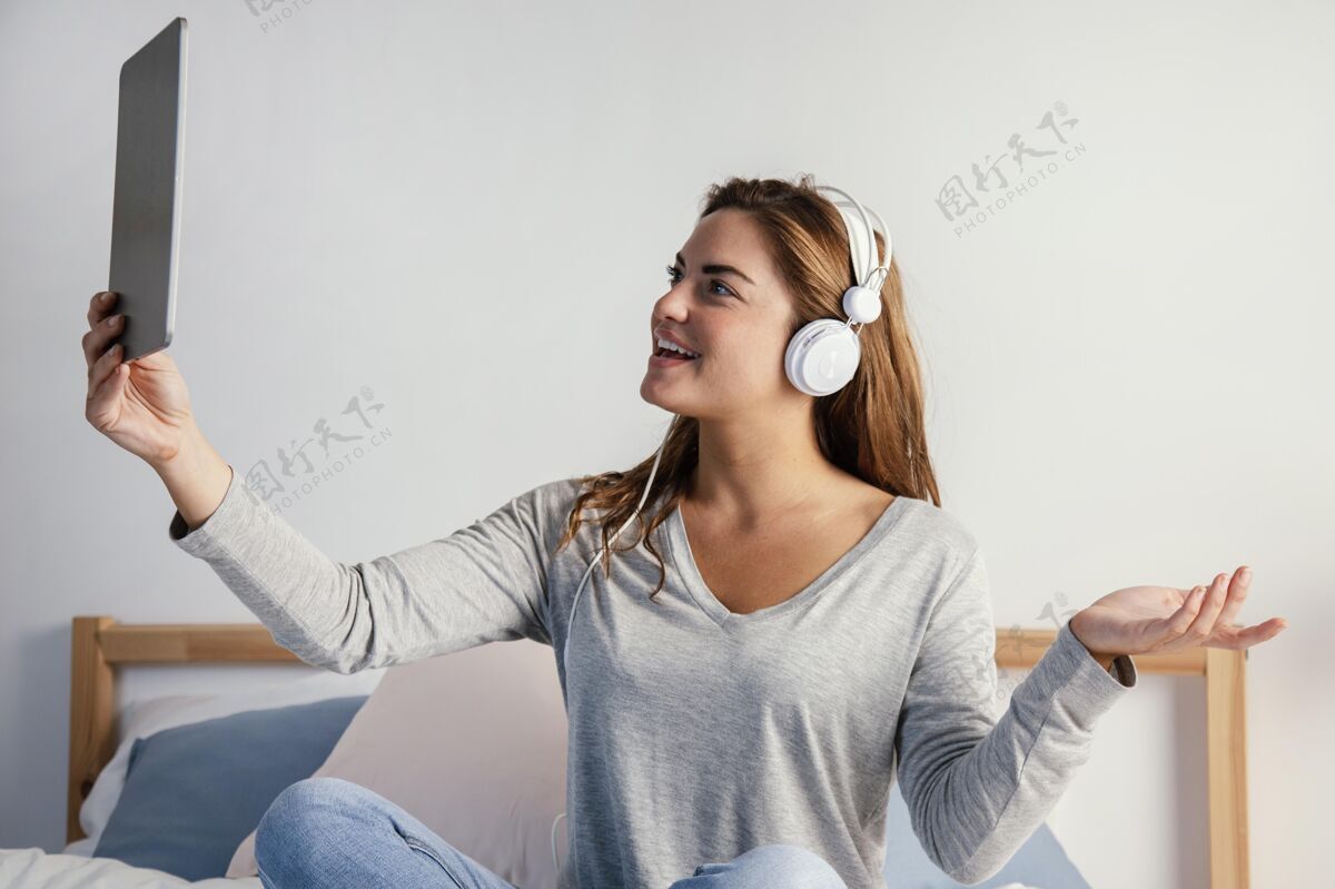 设备戴耳机的女人用平板电脑房子科技室内