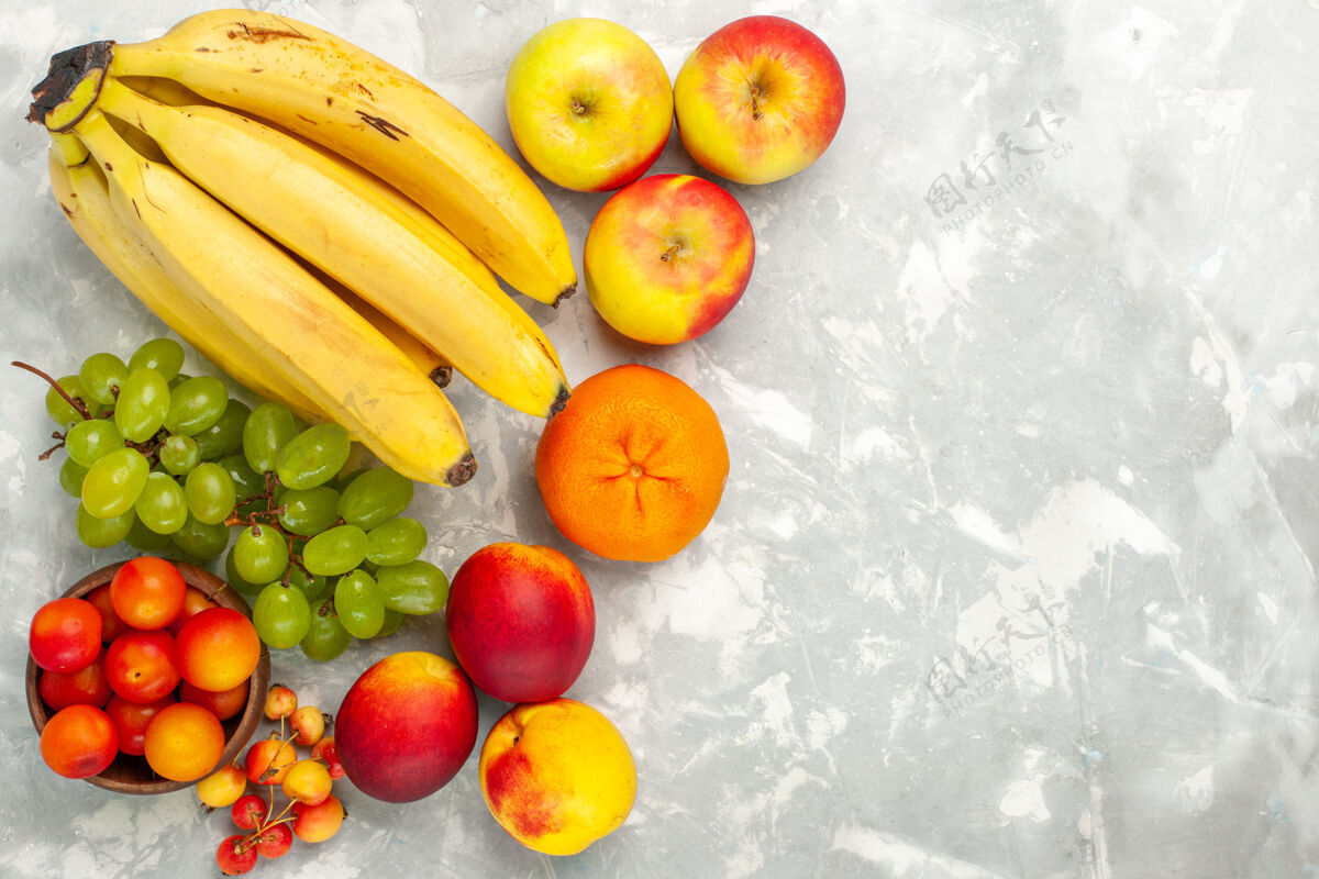 食品顶视图新鲜的黄色香蕉醇香可口的水果与葡萄苹果在淡白色的办公桌上苹果美味顶级