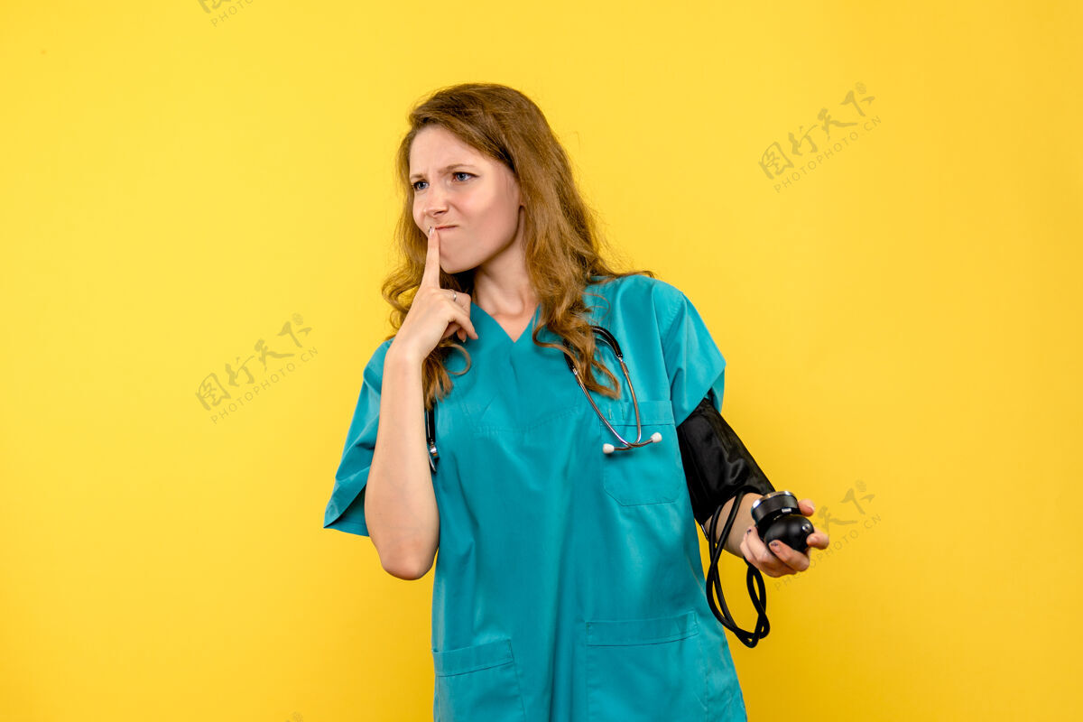 黄色前视图女医生在浅黄色空间测量压力肖像听诊器健康