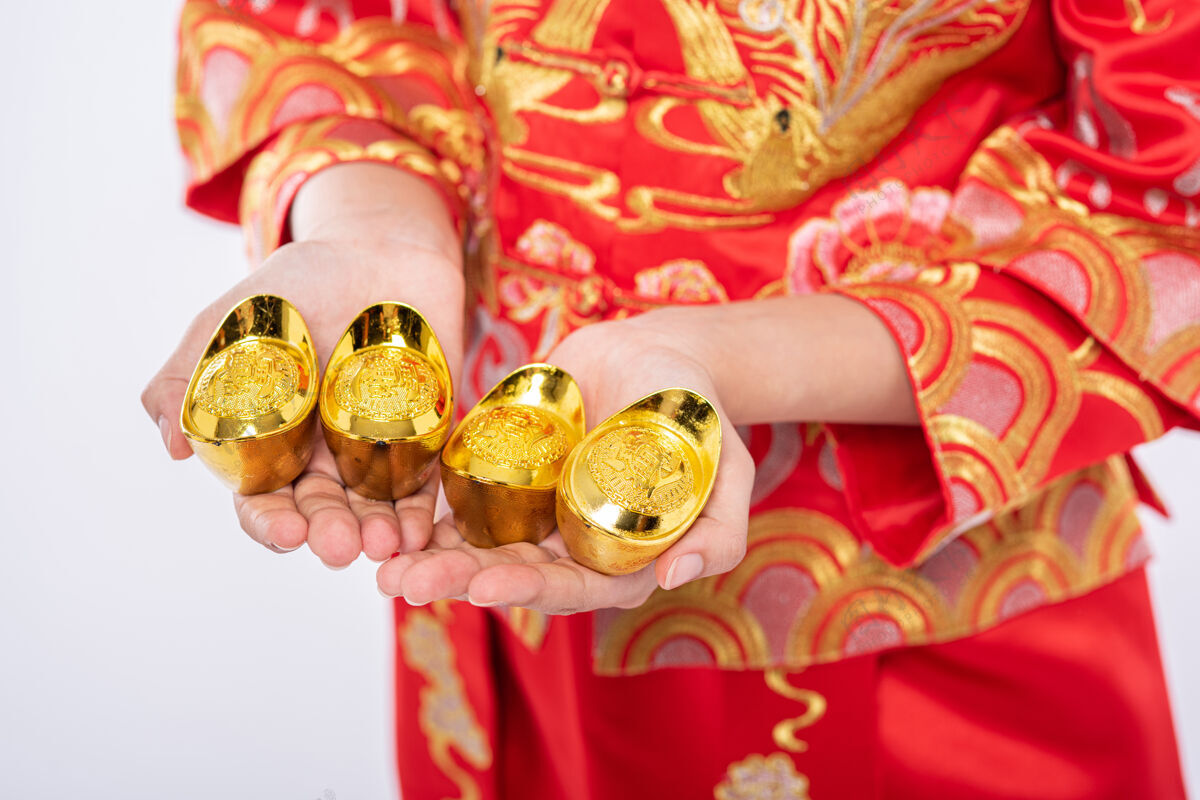 文化穿旗袍西服的女人在中国新年里给家人送去黄金 祝他们好运成人欢呼给予
