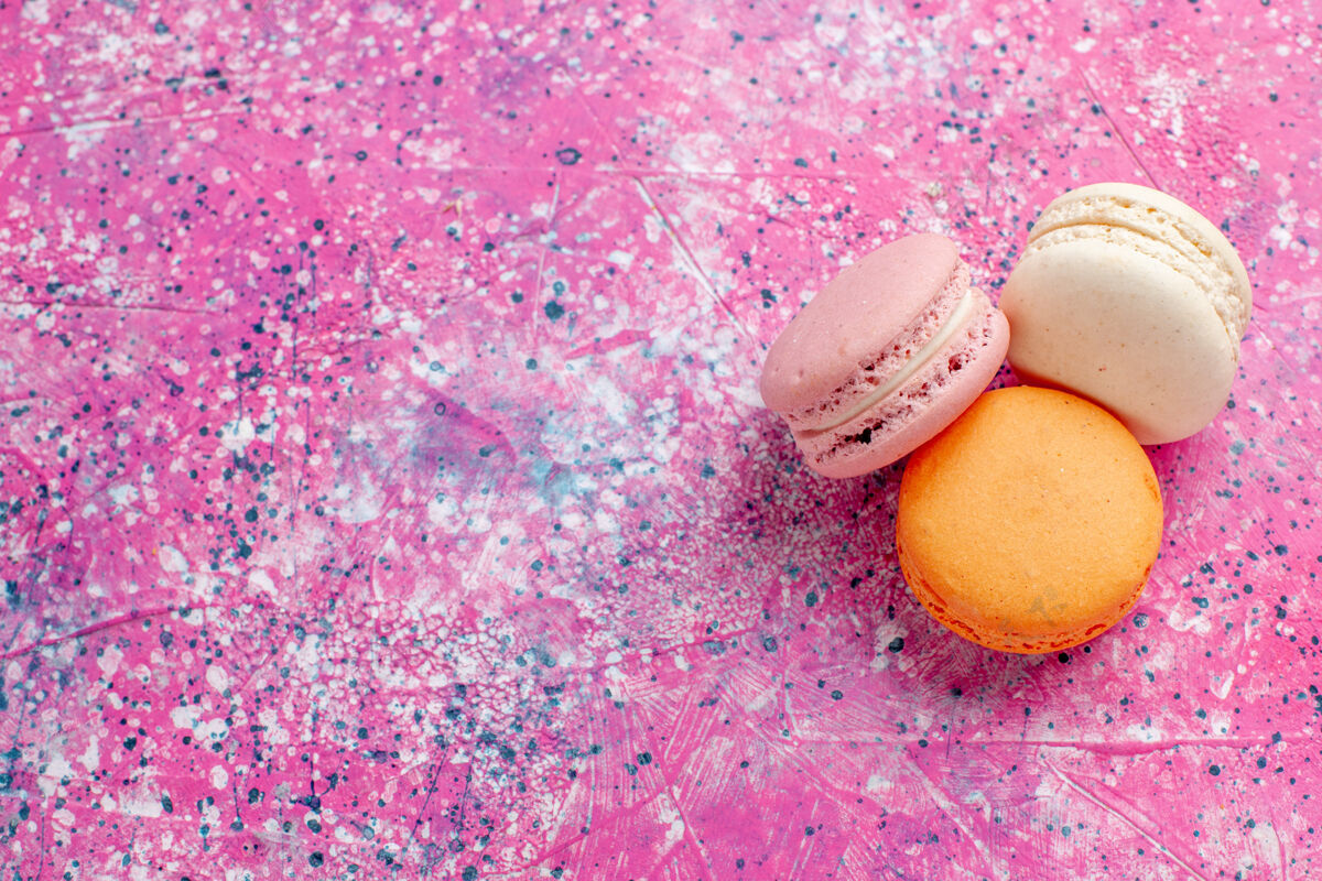 包装顶部近距离观看法国马卡龙美味的小蛋糕在粉红色的桌子上烤蛋糕甜甜的糖馅饼食物小复活节