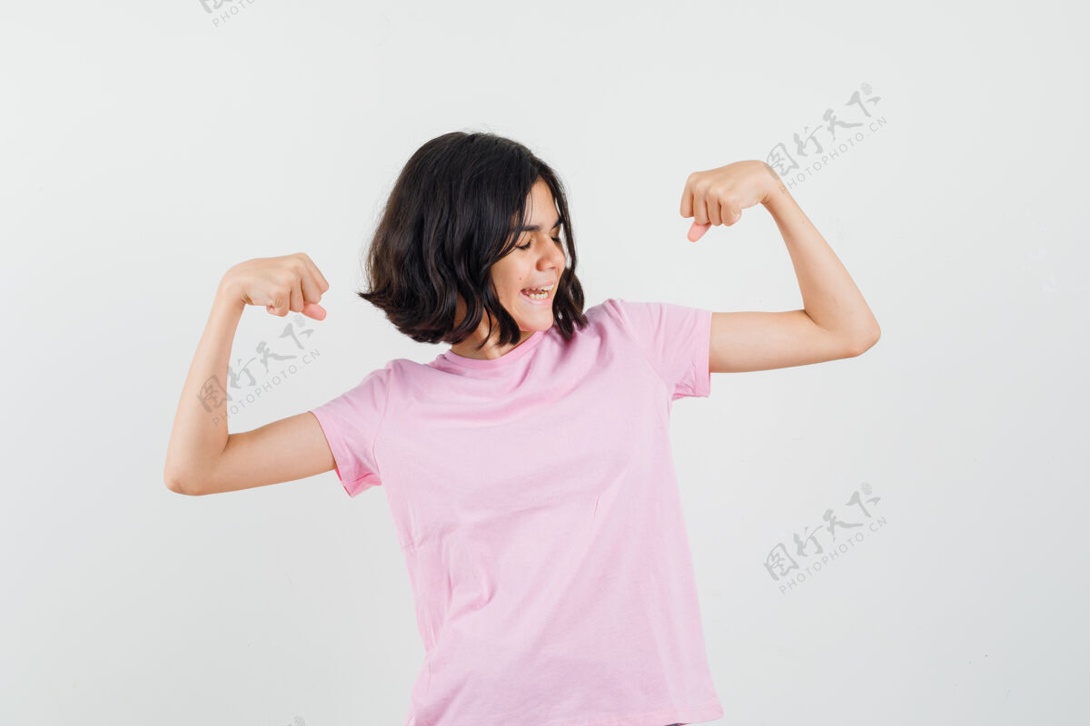 肌肉穿着粉色t恤展示手臂肌肉的小女孩 看起来很自信前视图漂亮休闲人物