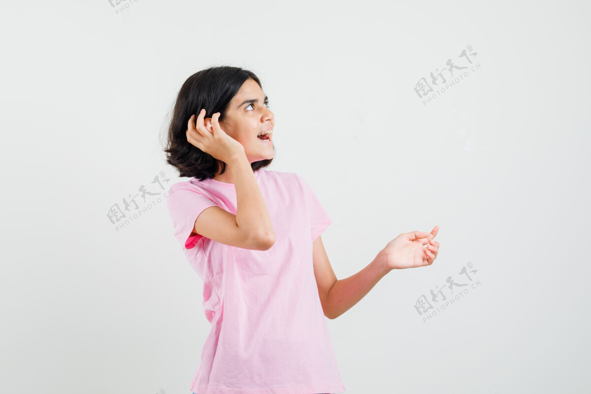 人穿着粉色t恤的小女孩手拉手靠近耳朵 看起来很好奇前视图人青少年休闲