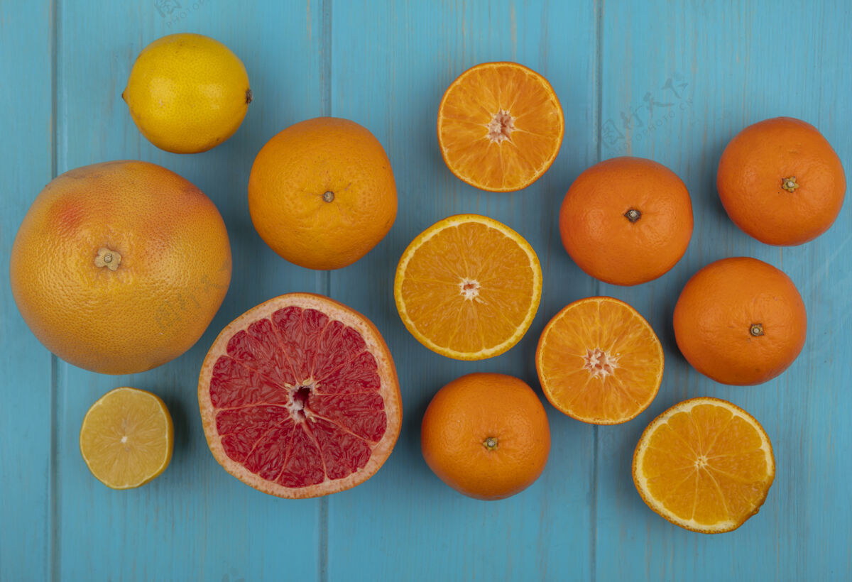 水果在绿松石色背景上 可以看到切片和整个橘子和葡萄柚的顶视图整个切片顶部