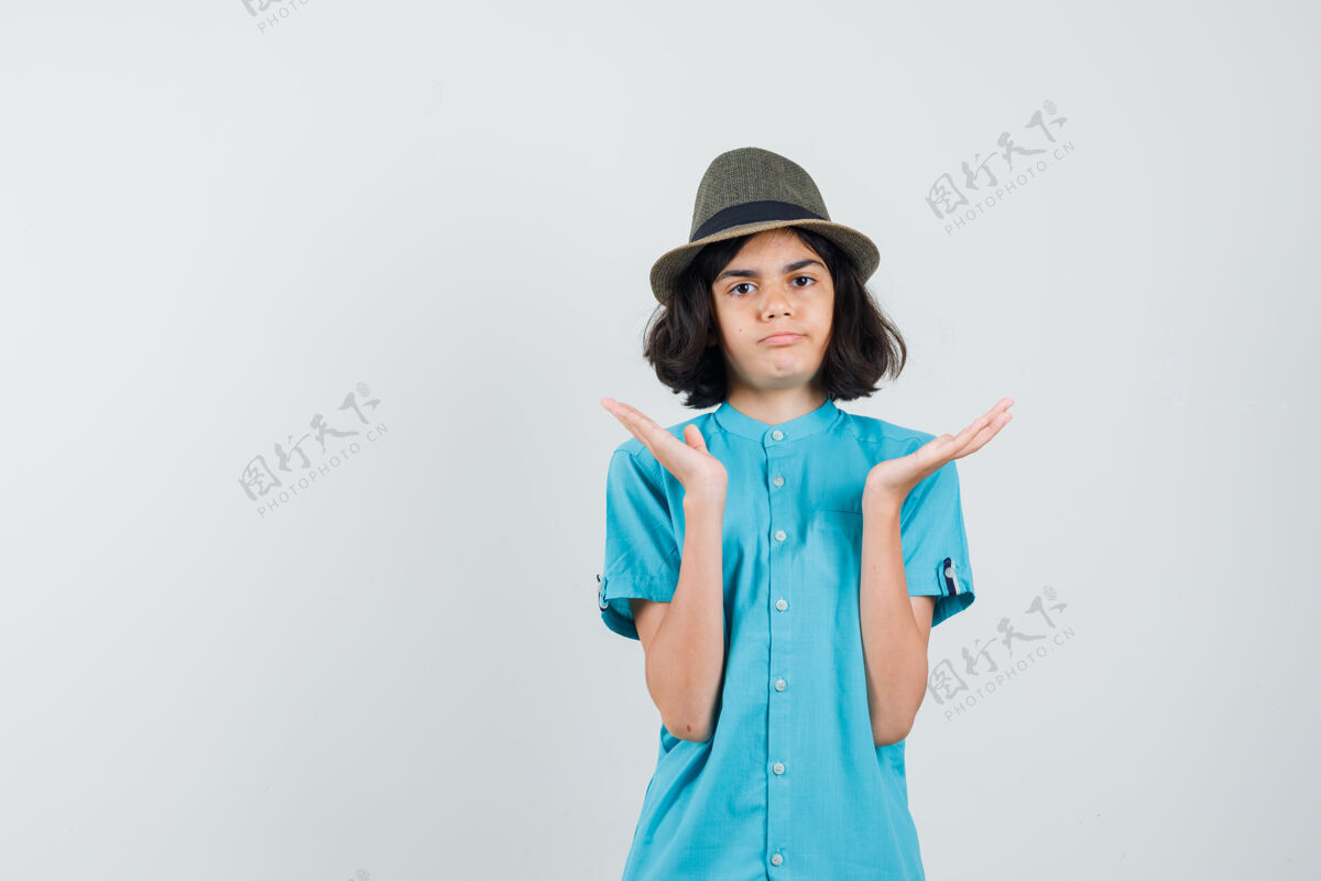 年轻穿着蓝色衬衫 戴着帽子的年轻女士举起双手 手掌张开优雅开放积极