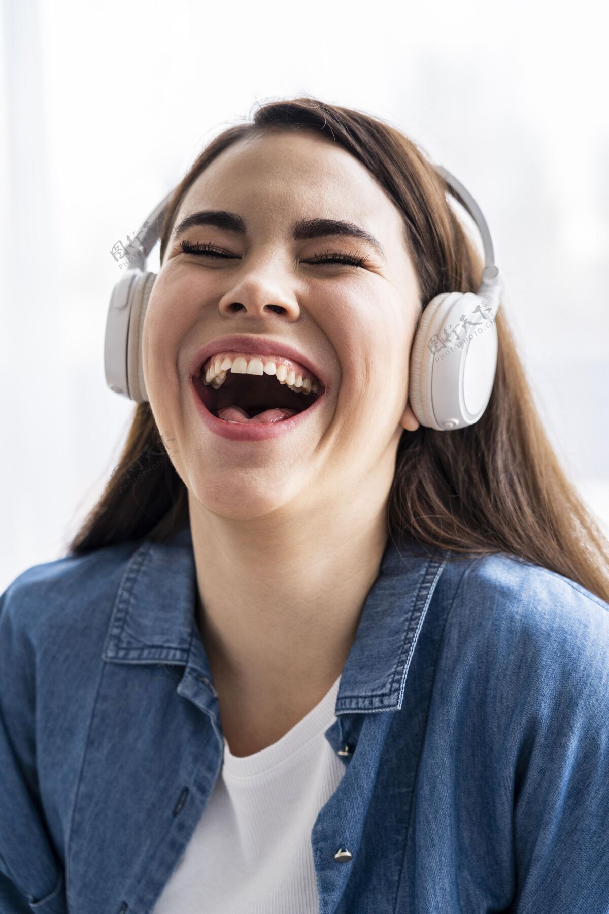垂直快乐的女人用耳机听音乐耳机国际积极