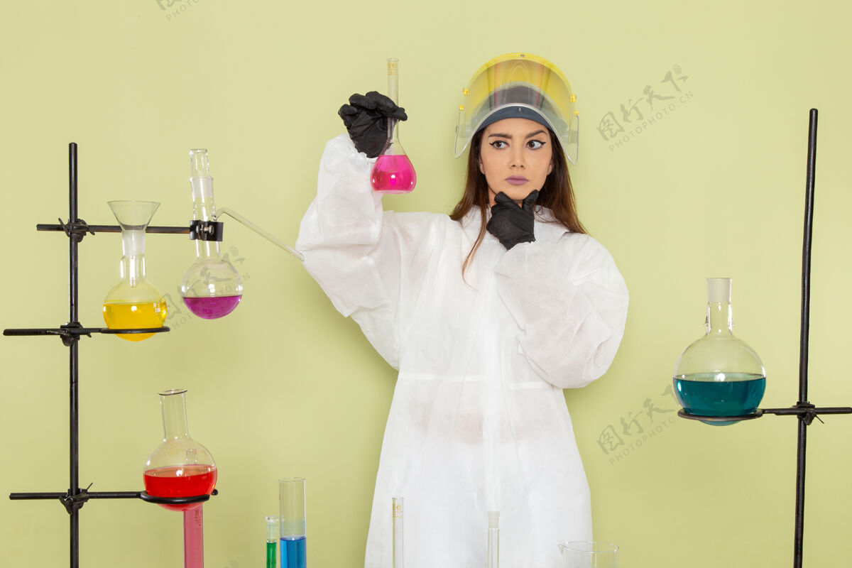 思维正面图身着特殊防护服的年轻女化学家在绿墙化学实验室化学工作中思考解决方案女性科学防护正面女性