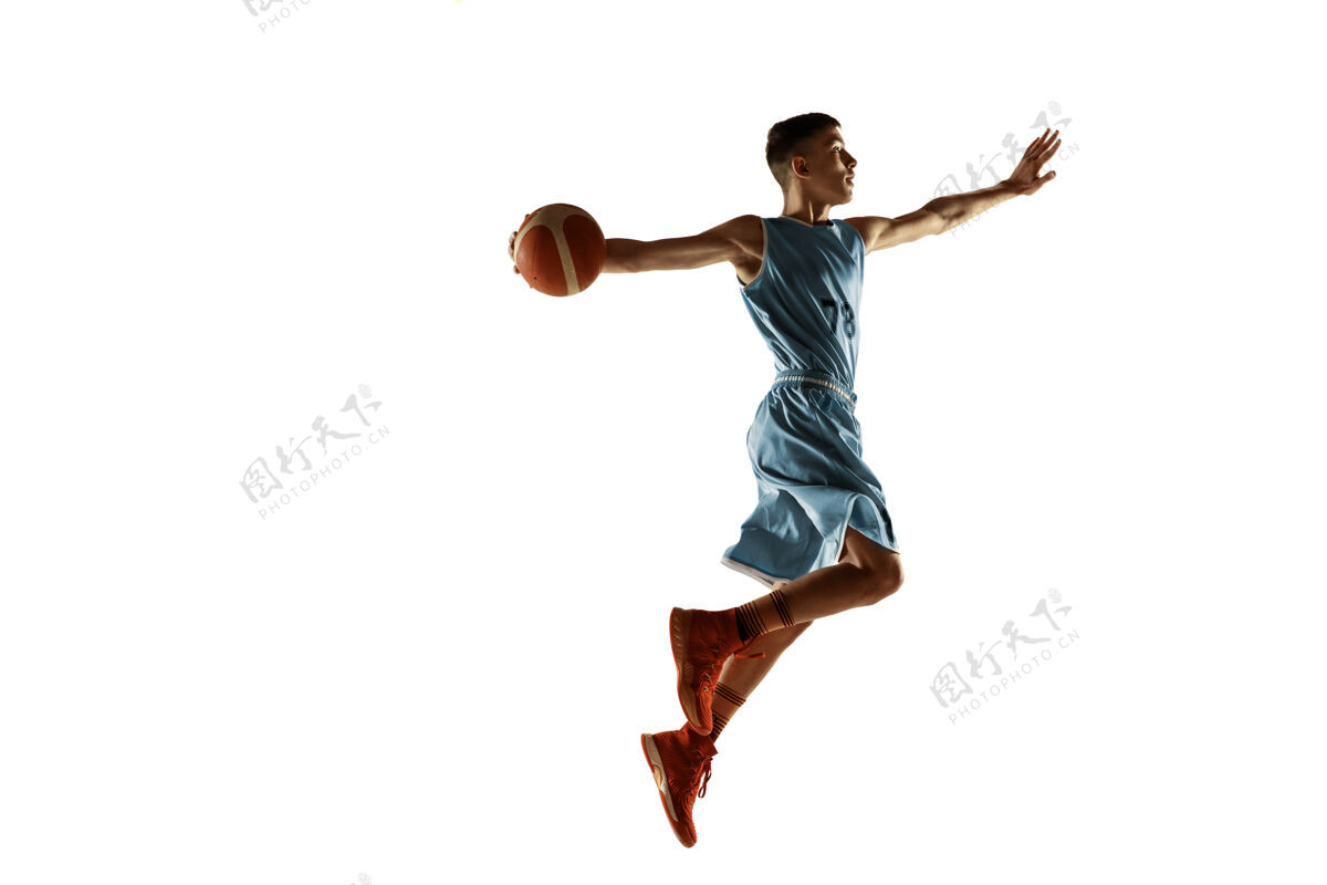 训练在白色工作室背景上 年轻篮球运动员拿着一个孤立的球的全长肖像青少年训练和练习 动作运动的概念 动作 健康的生活方式 广告肌肉动作持球