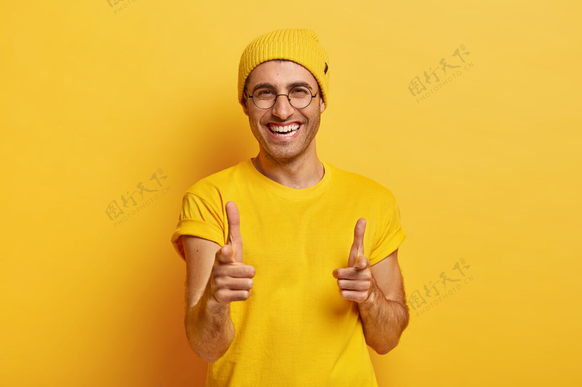 千禧一代快乐男人的画像指着镜头 选择你 高兴地看着镜头 笑容满面T恤乐观手指
