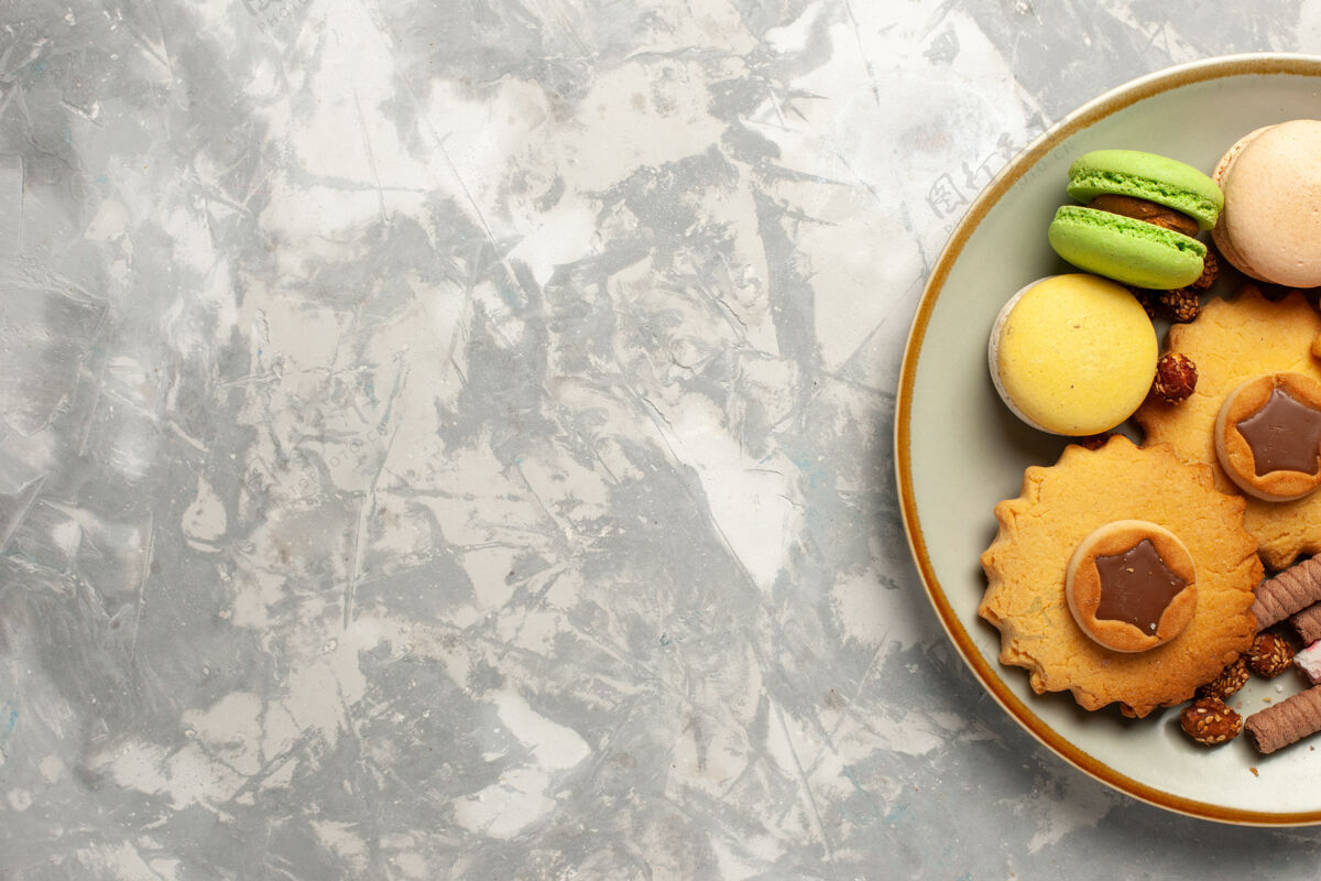 柑橘俯瞰法国麦卡龙蛋糕和饼干上的白色办公桌饼干饼干糖蛋糕甜馅饼生的减肥视野