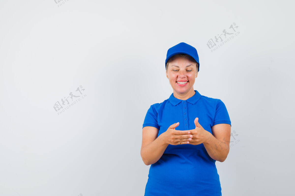 女士成熟的女人在看一件装在蓝色t恤里的东西姿势白发帽子