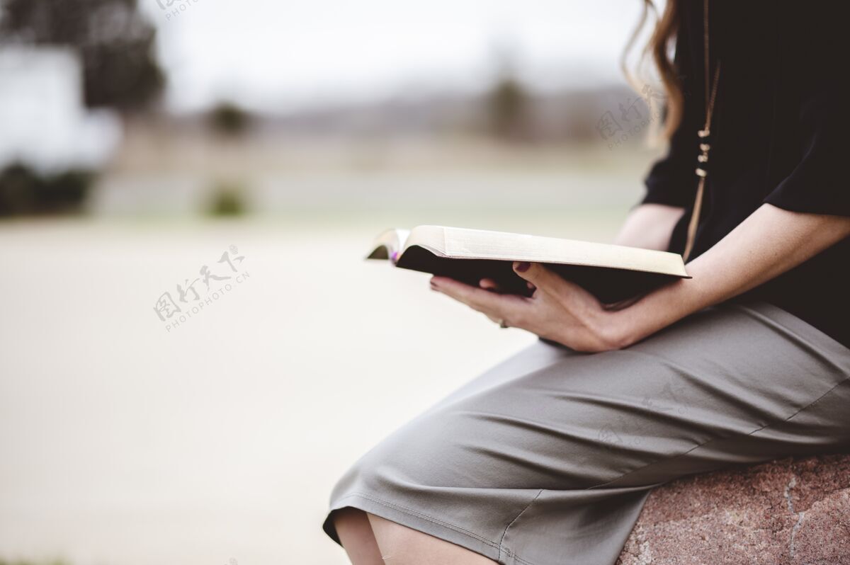 微笑坐在岩石上看书的女人坐着女人自然