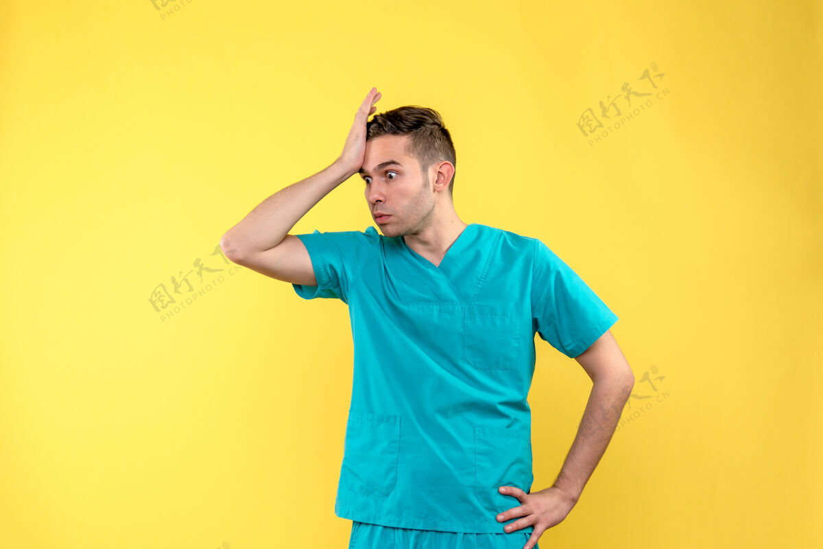抱歉黄色墙壁上一张愁容满面的男医生的正视图黄色休闲脸