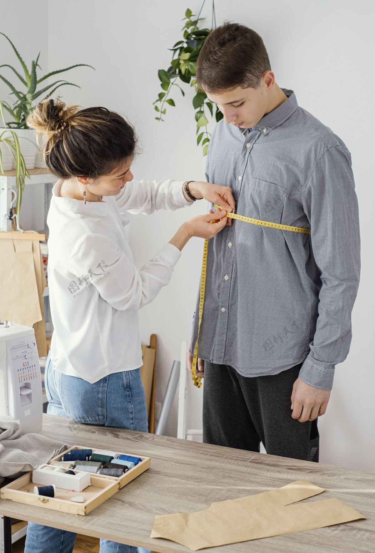 裁缝女裁缝测量男客户的衬衫男人昂贵的女人