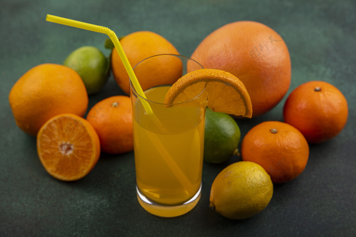 酸橙侧视图橙汁与柠檬橙和葡萄柚在一个绿色的背景玻璃绿色壁板食物