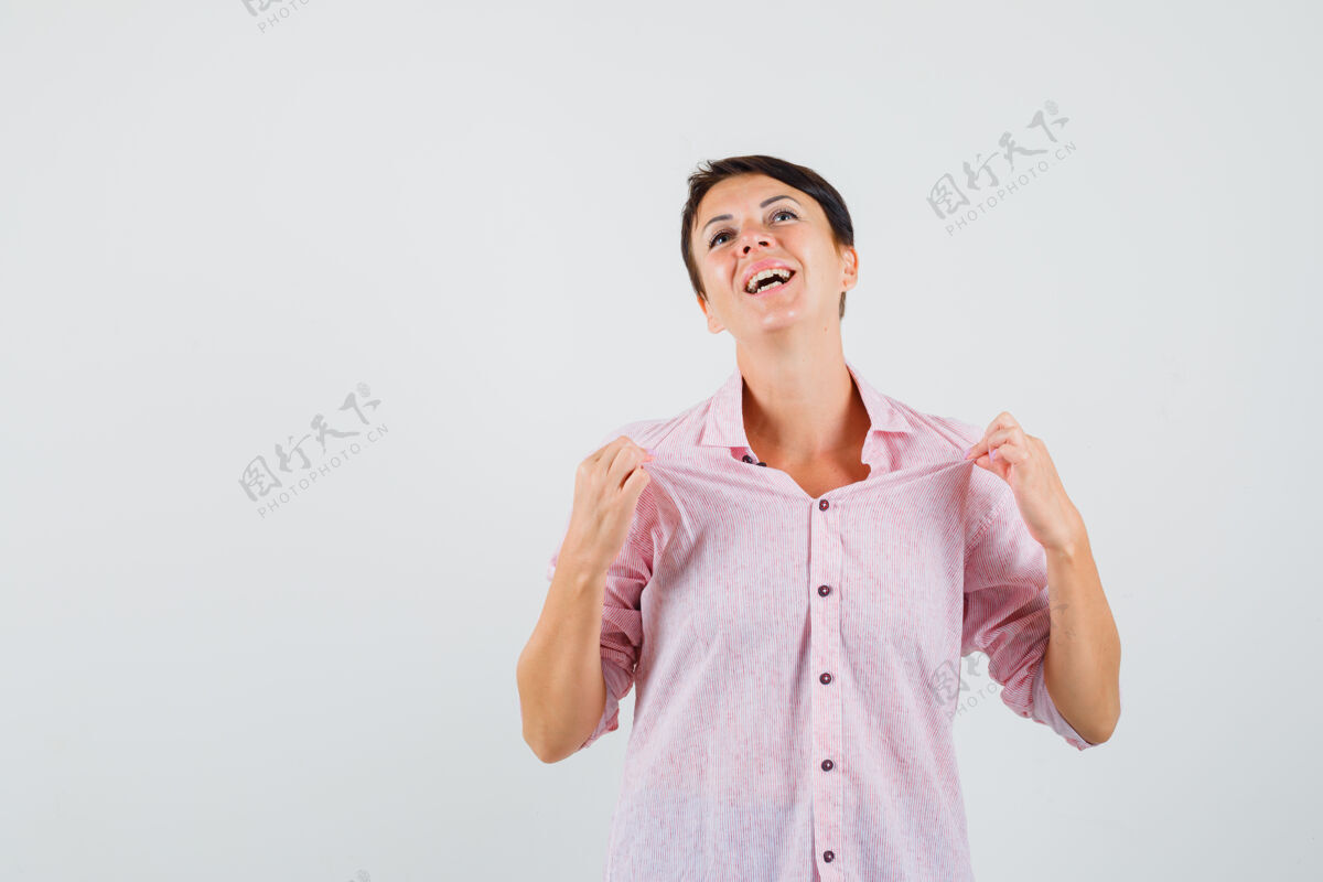 疾病穿着粉色衬衫的女性拉着她的衬衫 看起来很自豪 正面视图听看成人女人