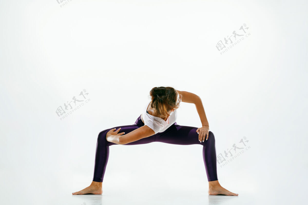 活动运动型年轻女性 在白色工作室背景下做瑜伽练习适合灵活的女性模特练习健活方式的概念 身体和心理发展之间的自然平衡专业健美操运动