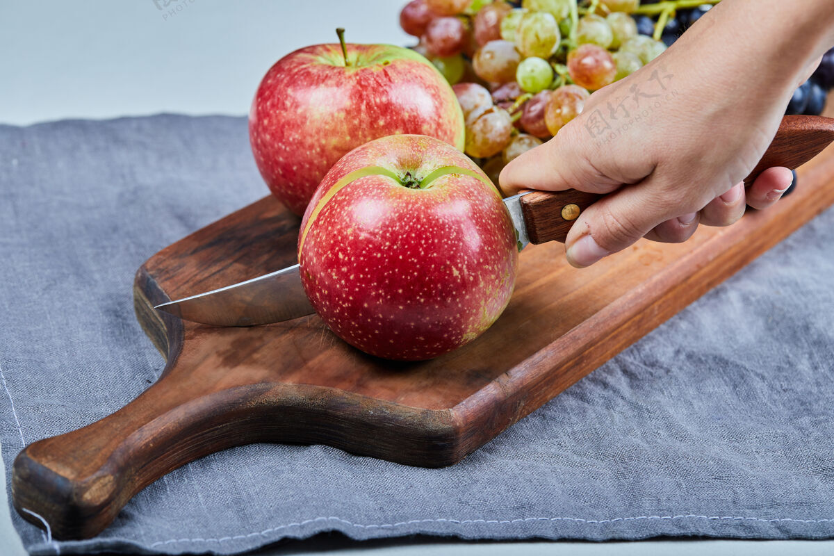 热带红苹果和葡萄串在木板上成分拼盘素食