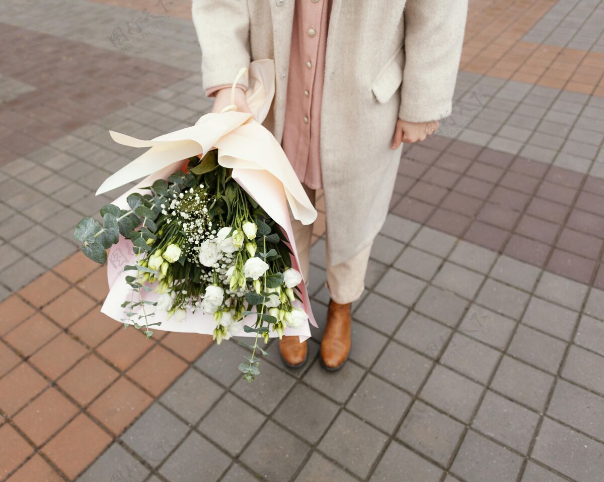 城市时尚女人在城市里捧着一束鲜花花束春天蔬菜