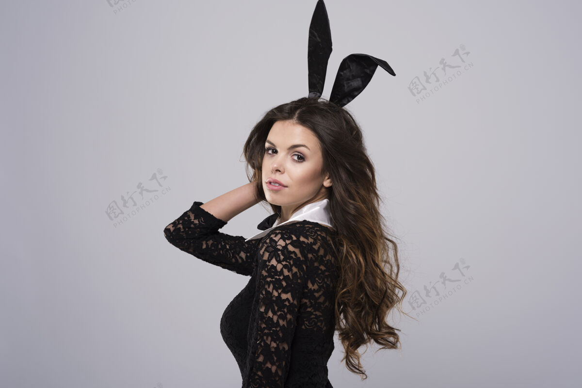 兔子忧郁的复活节兔子在黑色蕾丝服装女人服装站立