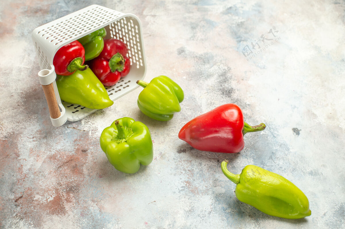 甜椒顶视图绿色和红色的辣椒从塑料筐散落在裸体表面与自由空间花椒蔬菜青椒和红椒