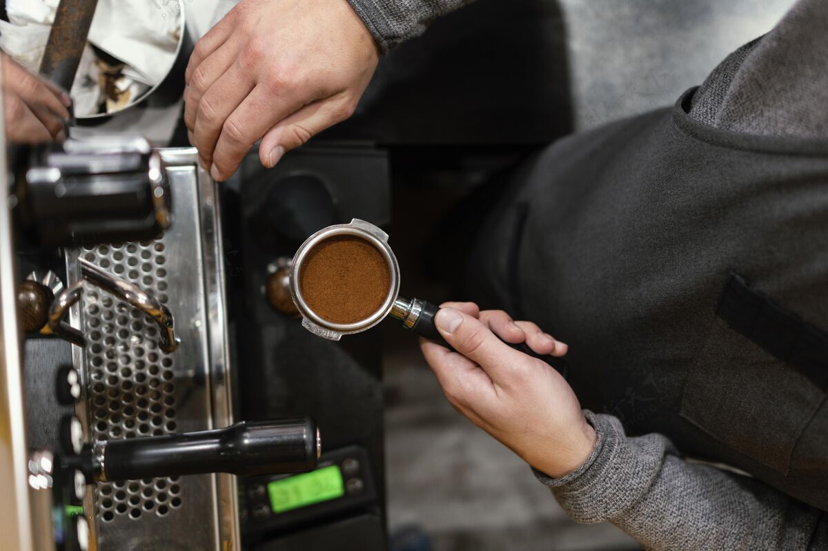 职业男咖啡师手捧专业咖啡机杯的平铺专业男性咖啡馆