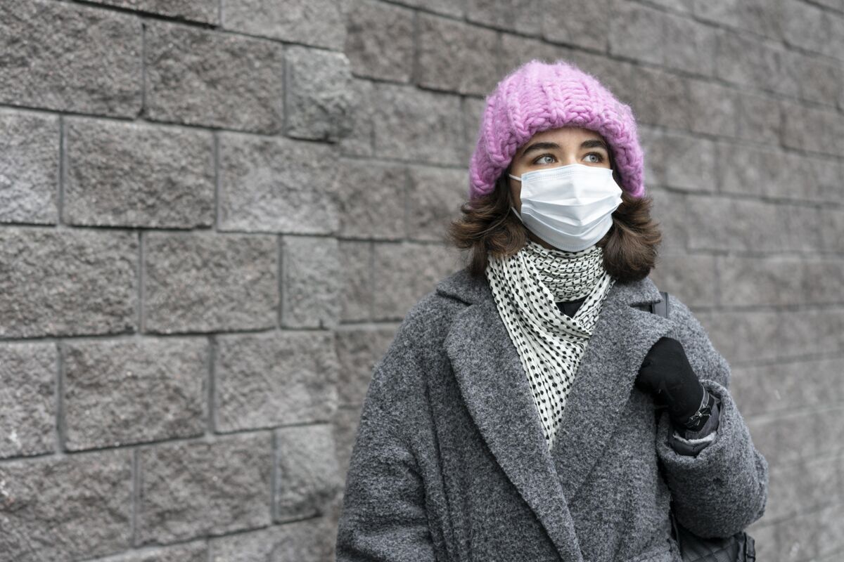 人戴着医用口罩的女人在城市里有复印空间人类流行病安全