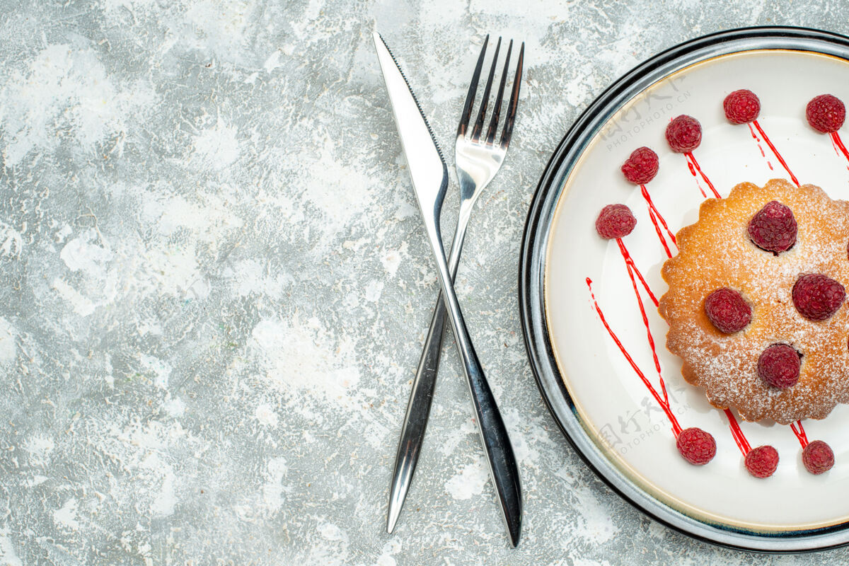景观俯瞰浆果蛋糕上的白色椭圆形餐叉和餐刀上的灰色表面自由空间餐厅浆果蛋糕叉子