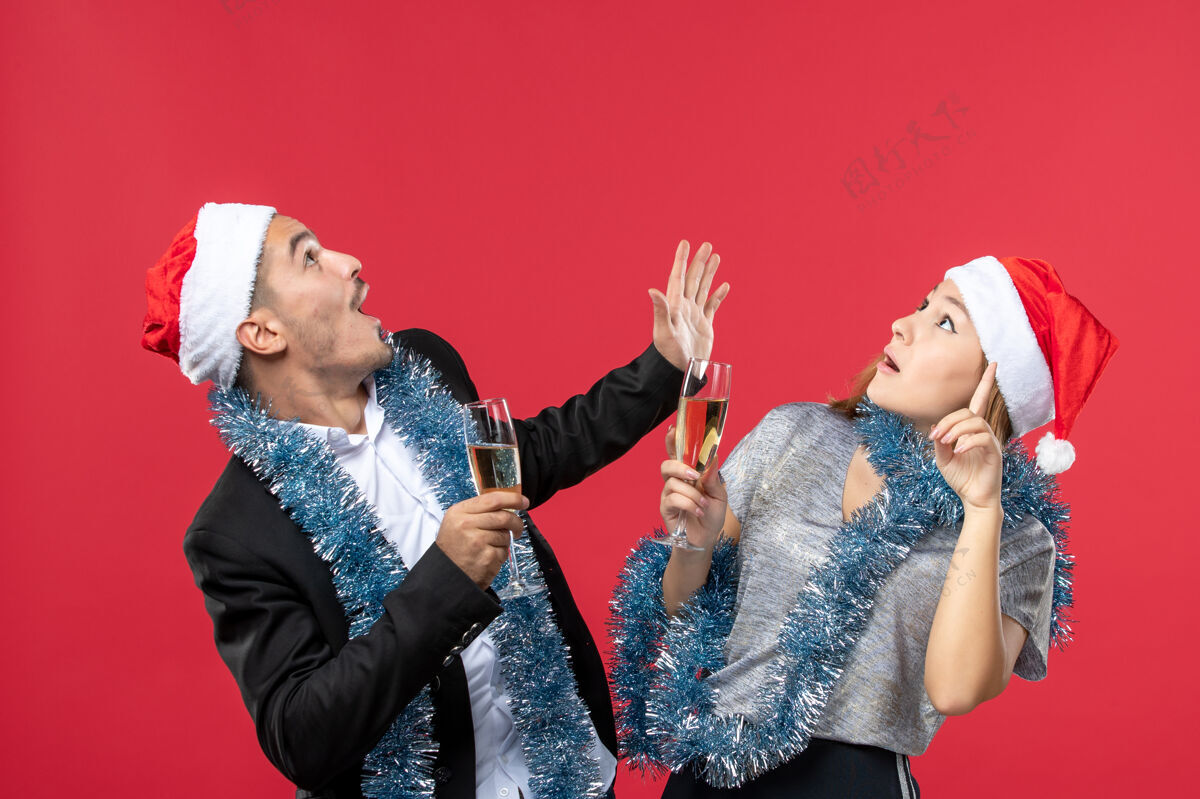 圣诞节正面图年轻夫妇在红墙派对上庆祝新年圣诞之爱表演公主风景