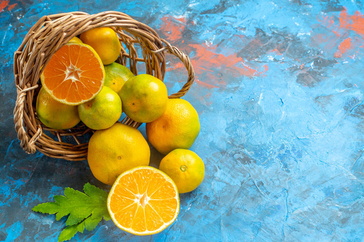 观点前视图新鲜的柑桔柳条篮子上的蓝色表面与复制空间篮子新鲜水果