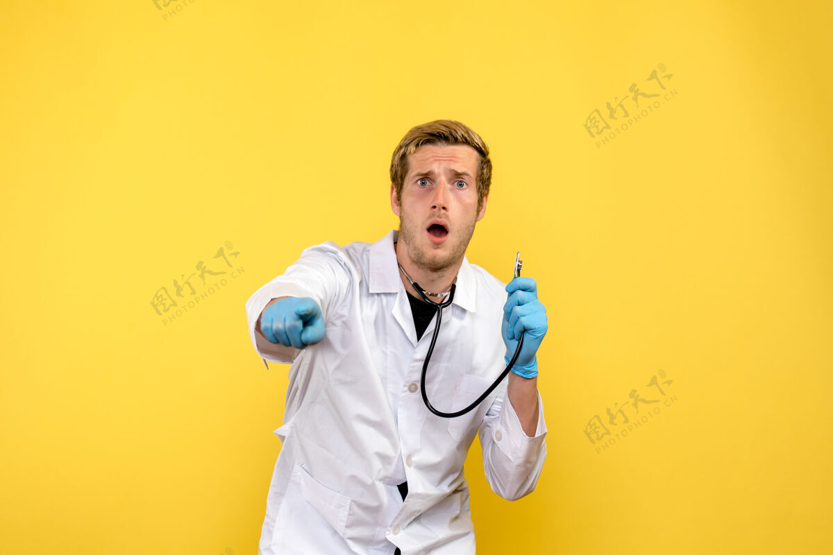 惊喜正面图男性医生惊讶于一个黄色背景的健康人体病毒医生医院医疗人