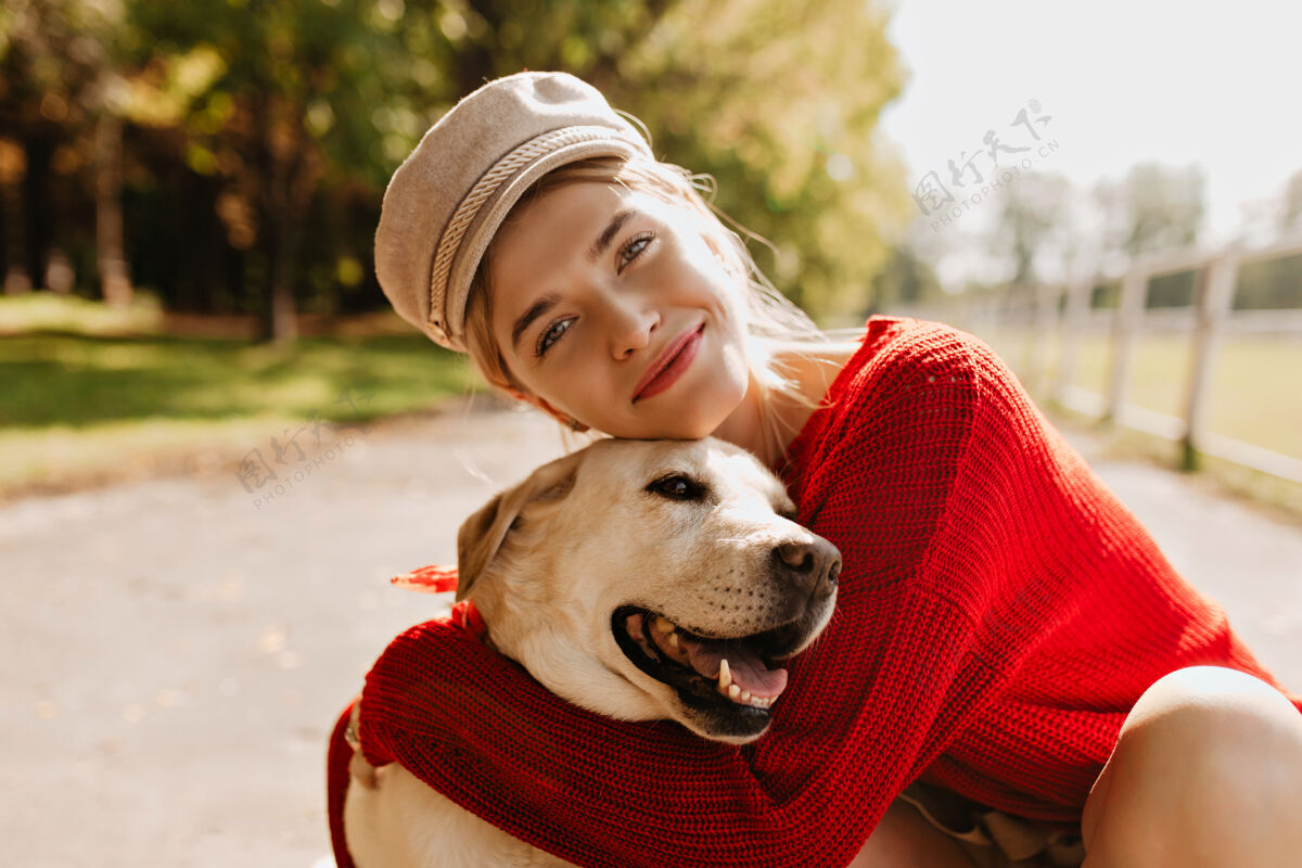 家养可爱的女孩和她的狗在秋天的公园里玩得很开心可爱的金发女郎摆着漂亮的狗造型多彩宠物步行者