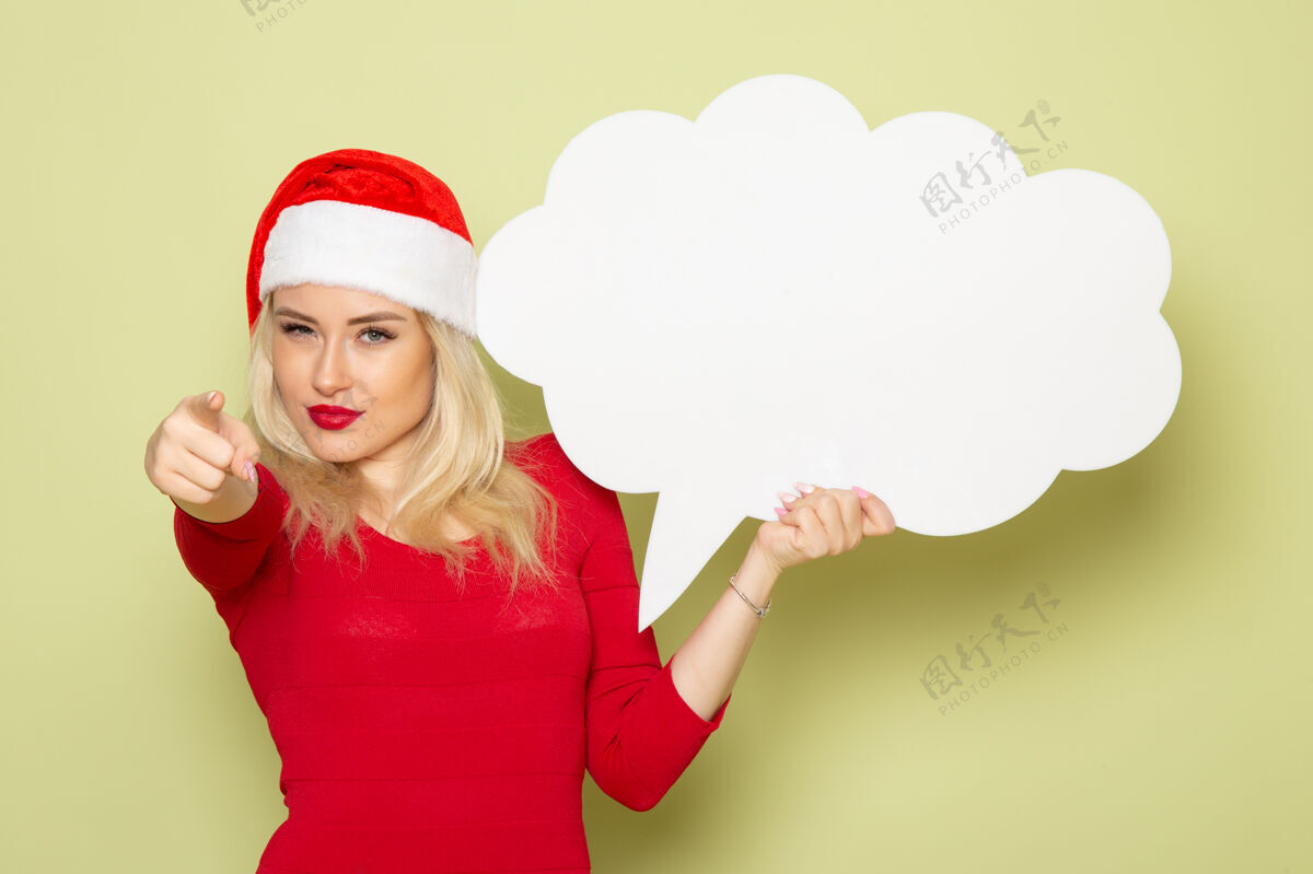 雪正面图美丽的女性手持大白标志在绿色墙上圣诞雪照片假日新年肖像大圣诞节
