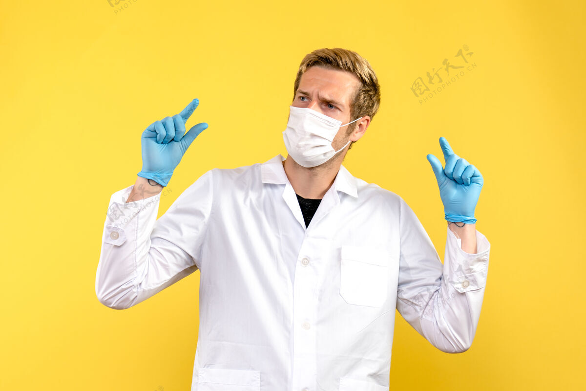 听诊器正面图黄桌上的男医生健康病毒大流行实验室外套病毒医院