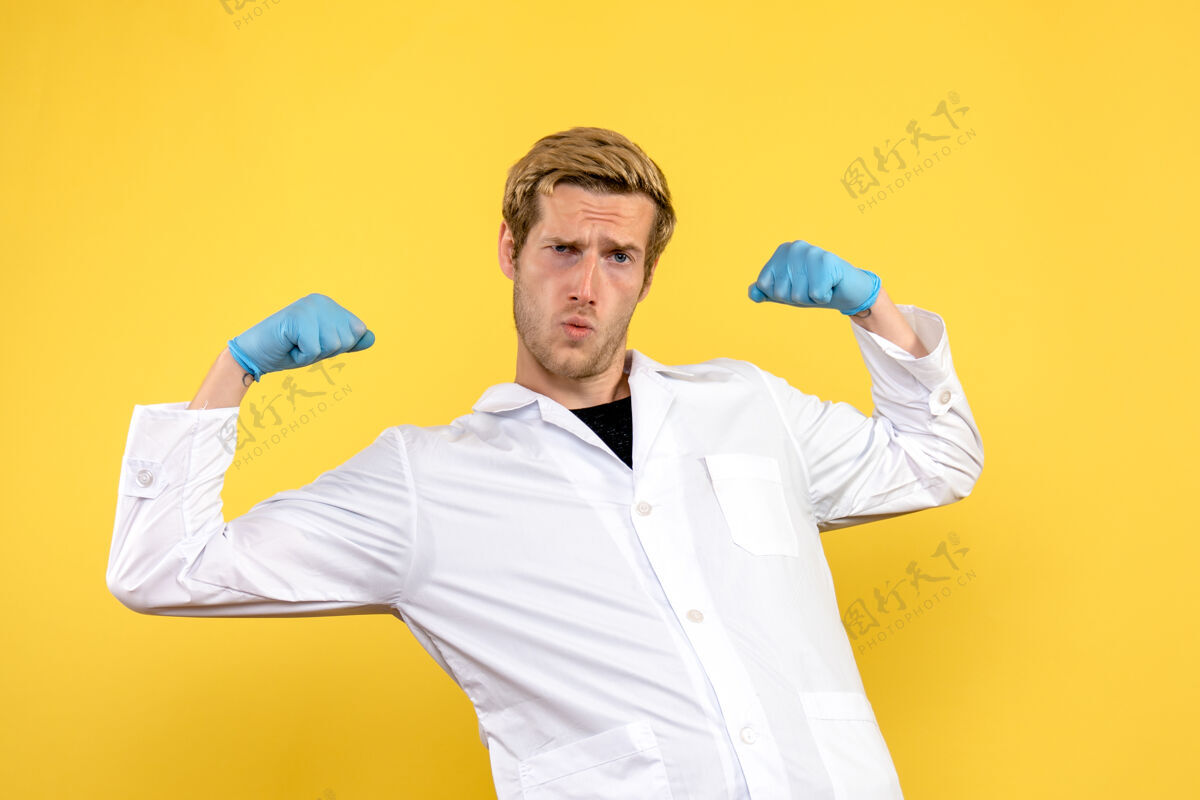商人正面图：年轻男性医生在黄色背景下展示人类病毒医学大流行流行病年轻男性医生医生