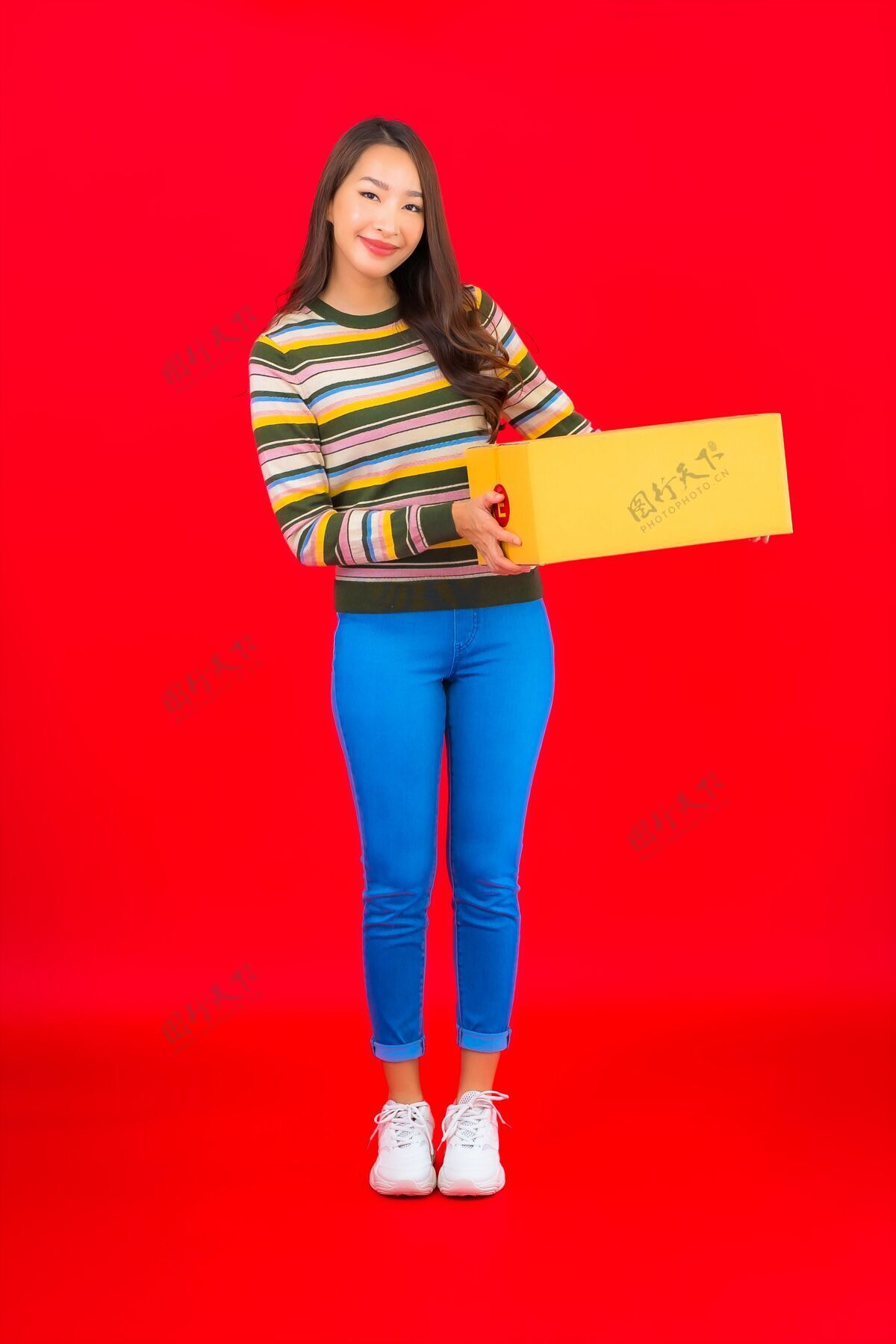 携带在红色的隔离墙上画一幅美丽的亚洲年轻女子拿着包裹盒发送纸板邮政