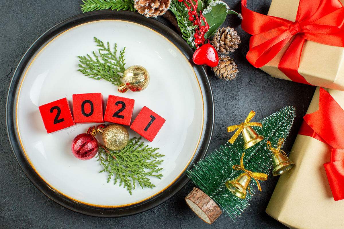 针叶树俯视图上的数字装饰配件板冷杉枝针叶树圆锥圣诞树上的黑暗背景碗餐午餐