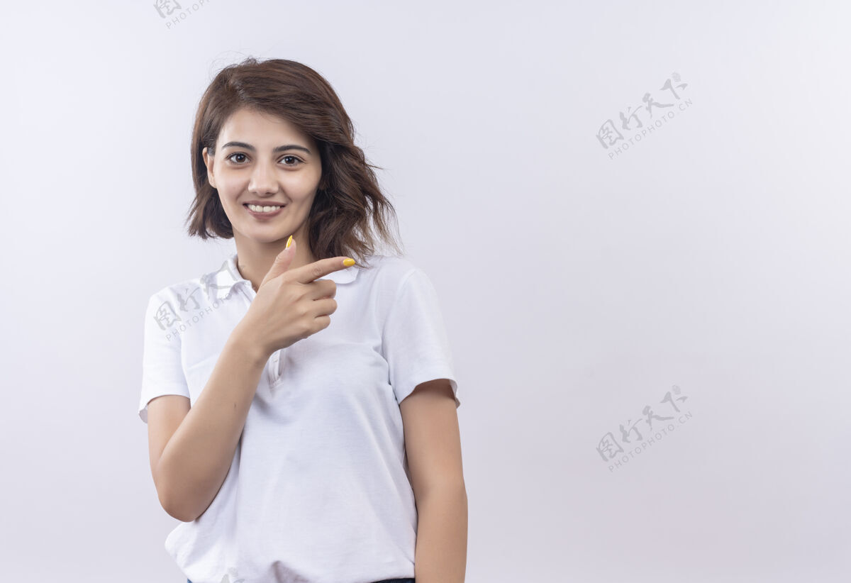 手指一个短发女孩穿着白色马球衫 微笑着积极和快乐 手指指向一边马球快乐微笑