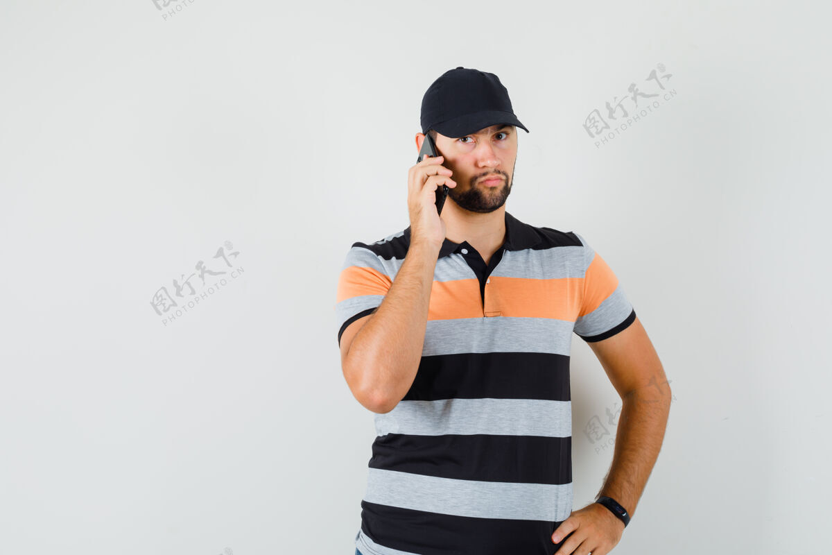 现代一个穿着t恤 戴着帽子 表情严肃的年轻人在讲手机休闲严肃朋友