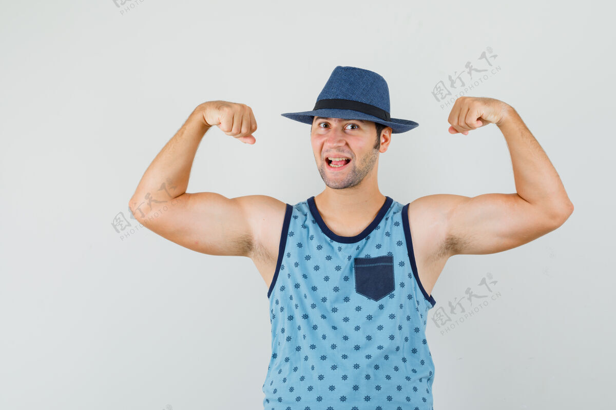 肌肉一个穿着蓝色单品的年轻人 戴着一顶展示手臂肌肉的帽子 看上去很有力量男性胡茬成功