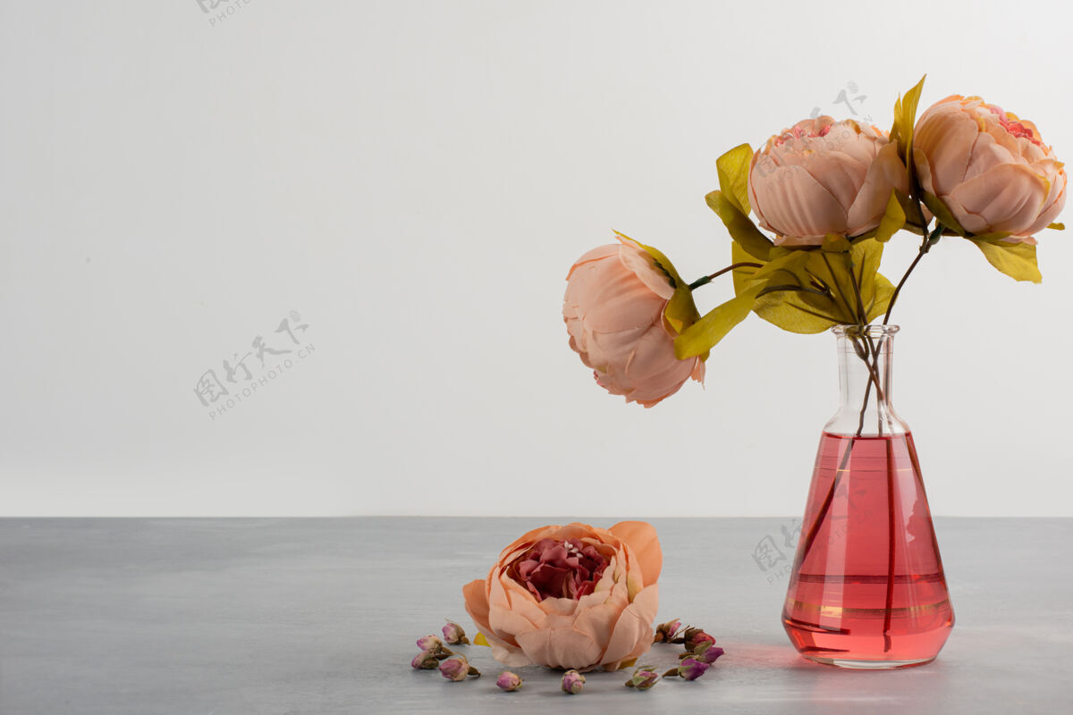 花瓶粉红色的牡丹玫瑰花在灰色的桌子上的玻璃花瓶里花瓣花花
