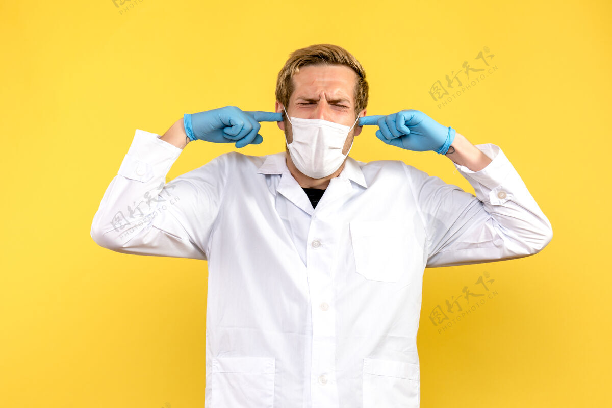 支架正面图：男医生在黄色背景上磕他的耳朵人面罩口吃