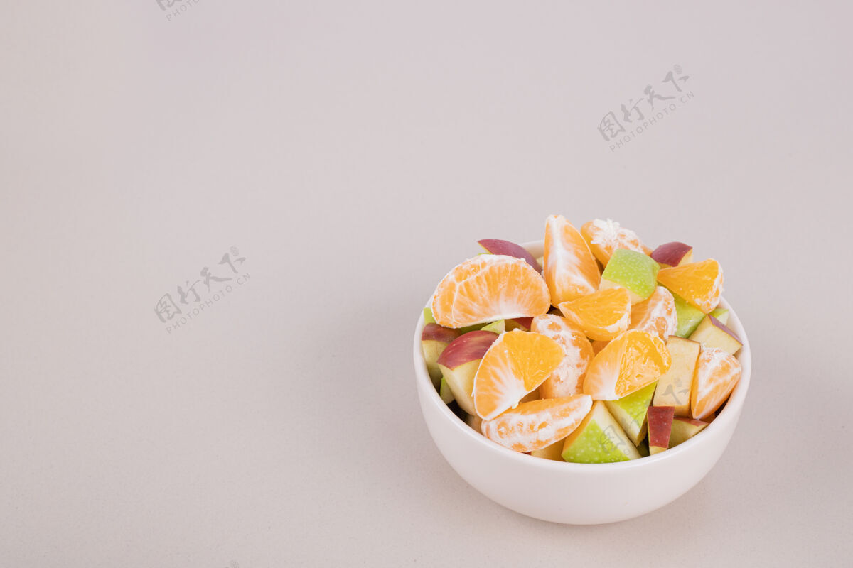 水果把新鲜水果切片放在白碗里苹果肥肉橘子