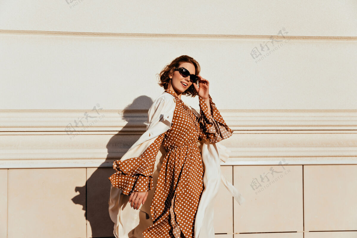 面孔穿着棕色长裙的漂亮女人享受着阳光明媚的日子穿着复古服装的可爱白人女孩走在街上女性休闲活跃
